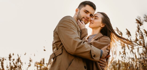 Pareja feliz de ángulo bajo en la naturaleza