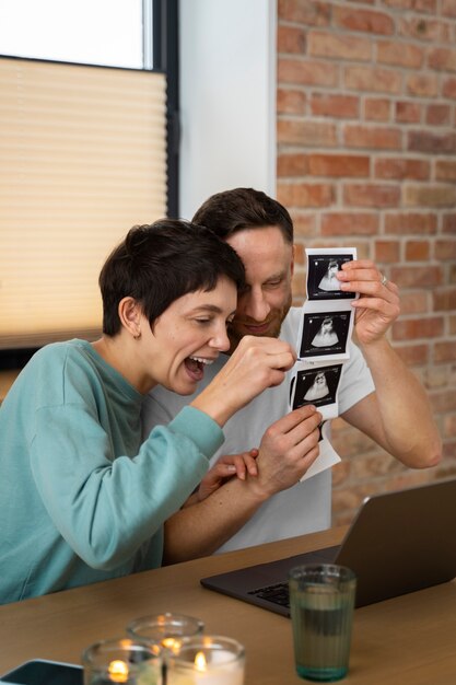 Pareja feliz anunciando embarazo por videollamada