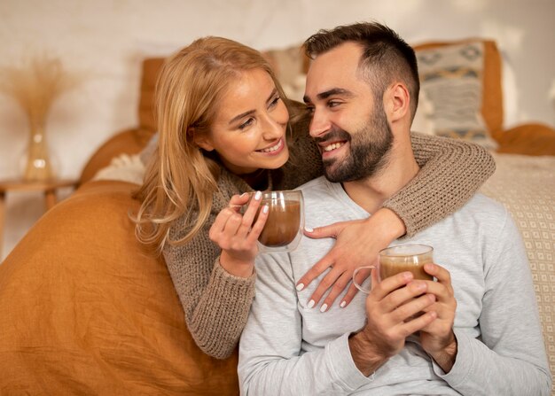 Pareja feliz con bebidas calientes