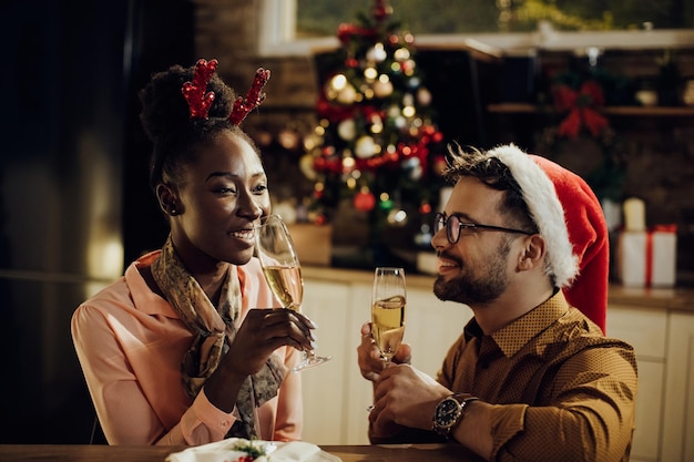 Una pareja feliz bebiendo champán mientras celebra el Año Nuevo en casa