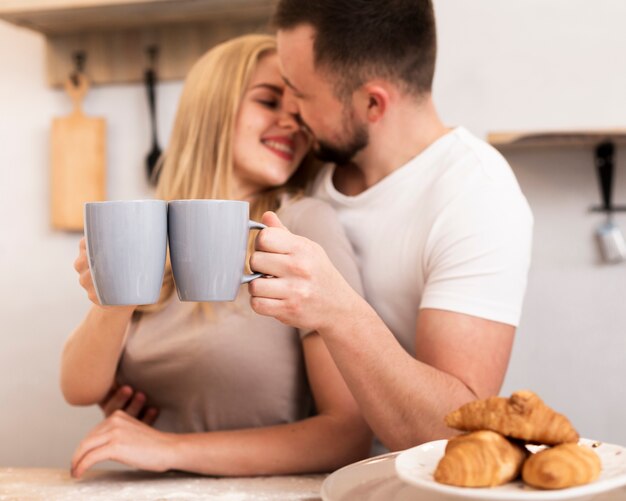 Pareja feliz bebiendo leche con croissants