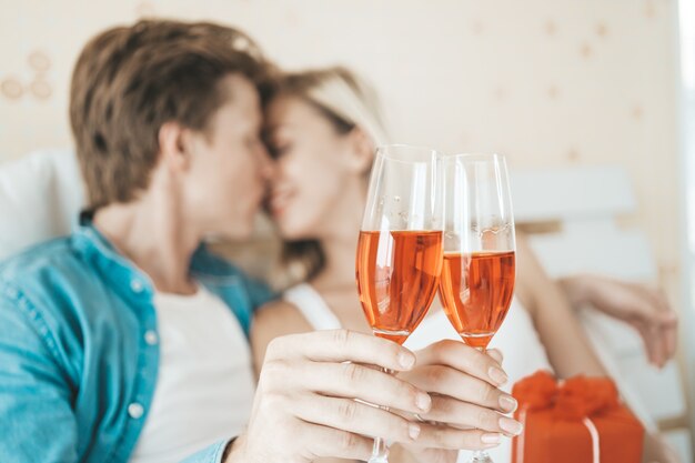 Pareja feliz bebiendo vino en la habitación