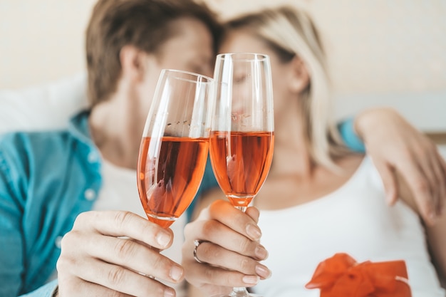 Pareja feliz bebiendo vino en la habitación