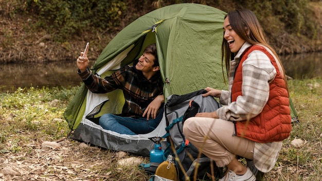 Foto gratuita pareja feliz en el bosque haciendo fotos del uno mismo