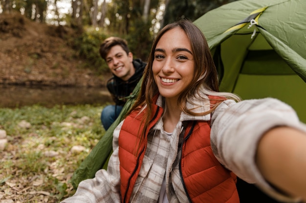 Pareja feliz en el bosque tomando un selfie