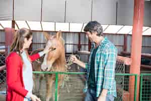 Foto gratuita pareja feliz con un caballo