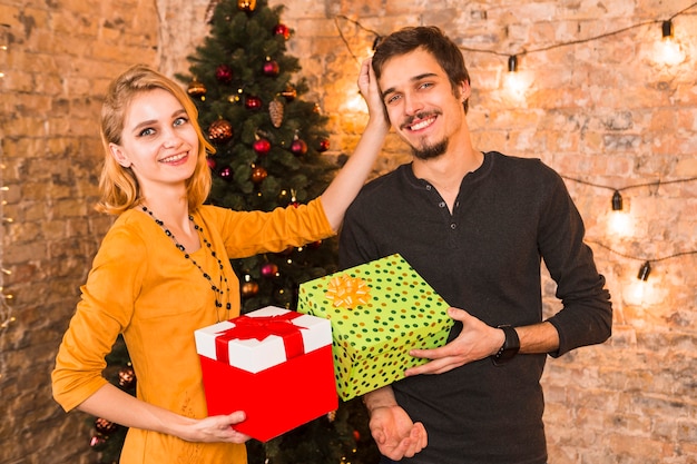 Foto gratuita pareja feliz con cajas de regalo