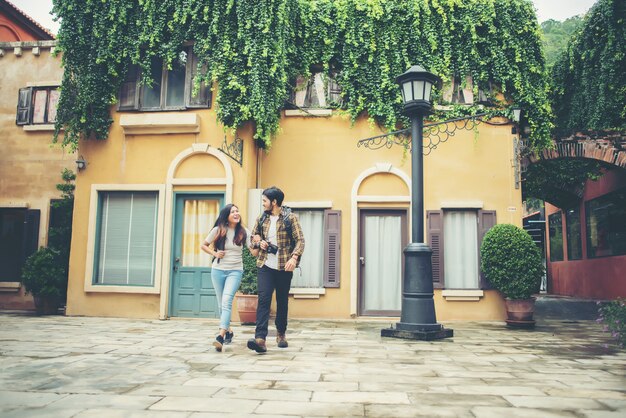 Pareja feliz caminando en los turistas urbanos, adultos jóvenes en viaje urbano caminando juntos.