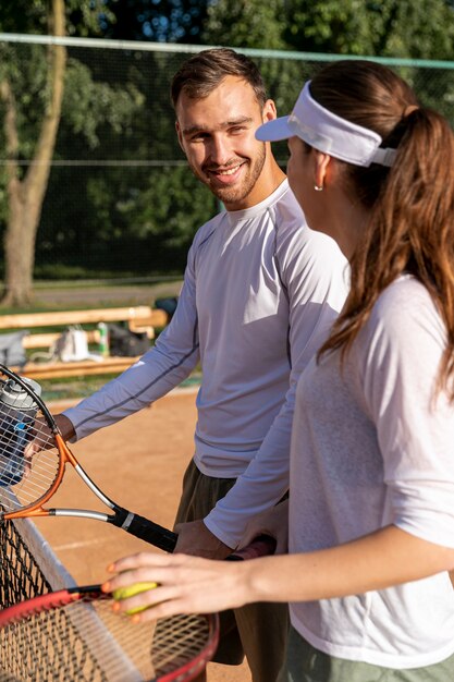 Pareja feliz en la cancha de tenis