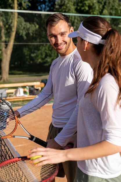 Pareja feliz en la cancha de tenis