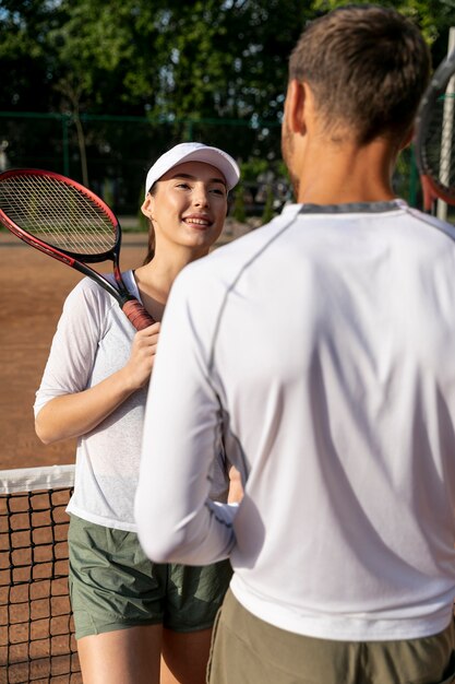 Pareja feliz en la cancha de tenis