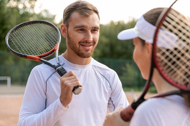 Pareja feliz en la cancha de tenis