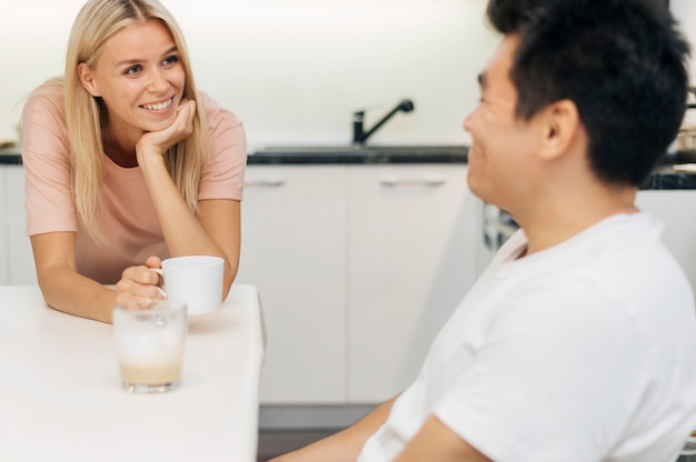 Pareja feliz en casa durante la pandemia conversando