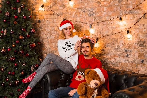 Pareja feliz celebrando navidad con peluche