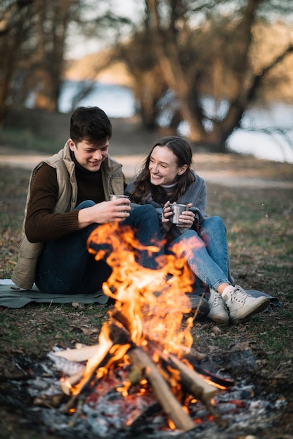 Pareja feliz cerca de fogata