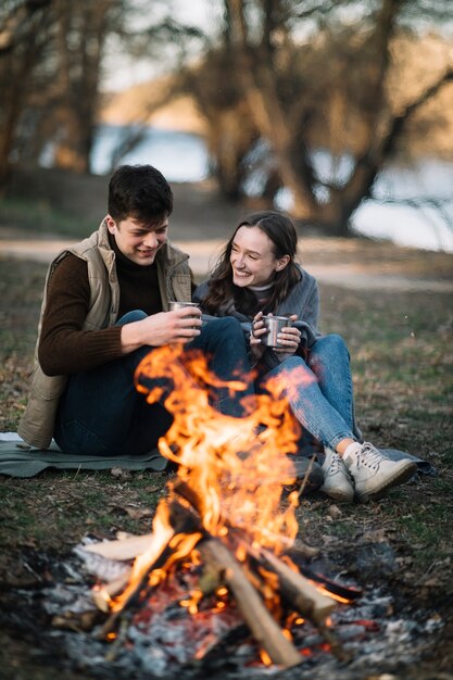 Pareja feliz cerca de fogata