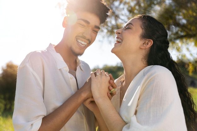 Foto gratuita pareja feliz cogidos de la mano vista lateral