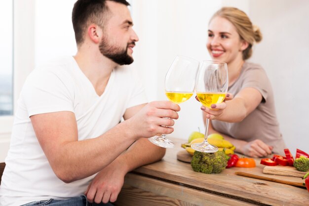 Pareja feliz comiendo verduras y bebiendo juntos