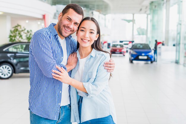 Pareja feliz en concesionario de coches