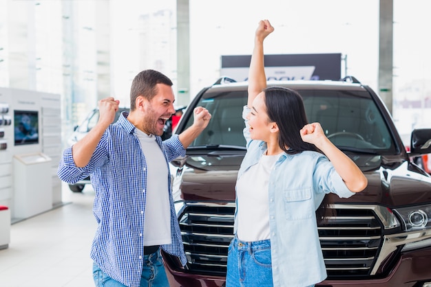 Pareja feliz en concesionario de coches