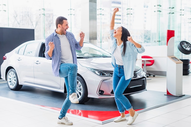 Pareja feliz en concesionario de coches