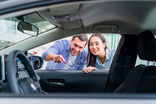 Pareja feliz en concesionario de coches