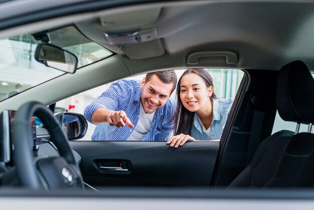 Pareja feliz en concesionario de coches