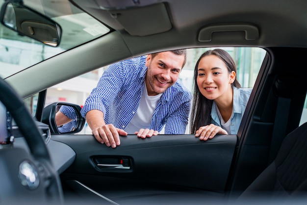 Pareja feliz en concesionario de coches