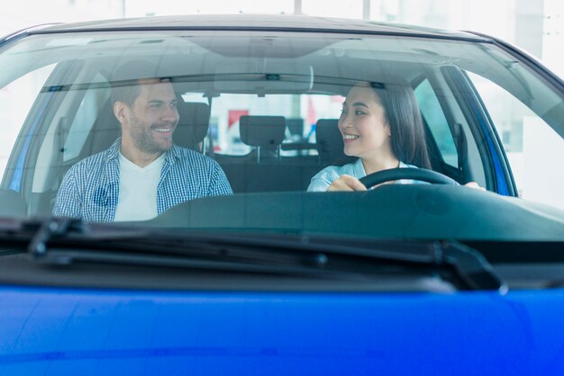 Pareja feliz en concesionario de coches