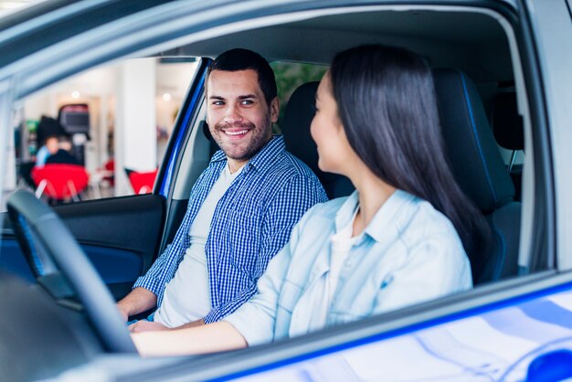 Pareja feliz en concesionario de coches