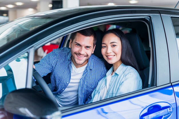 Pareja feliz en concesionario de coches