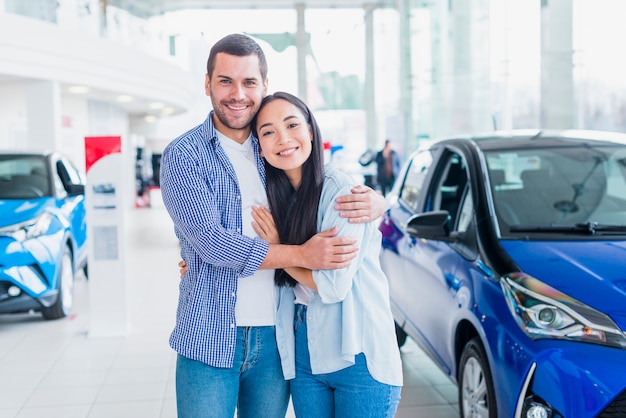 Pareja feliz en concesionario de coches