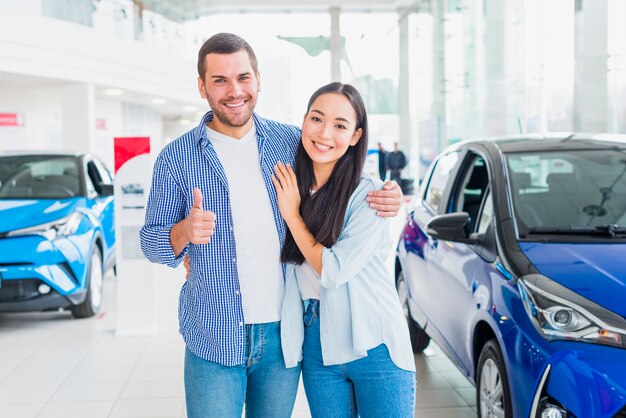 Pareja feliz en concesionario de coches