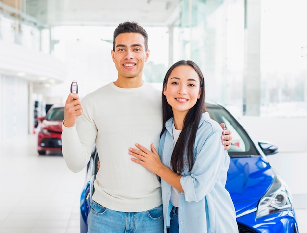 Pareja feliz en concesionario de coches