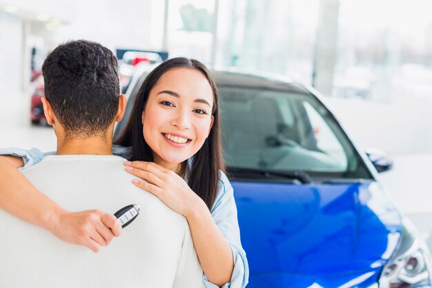 Pareja feliz en concesionario de coches