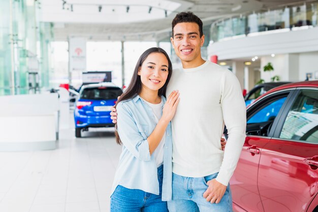 Pareja feliz en concesionario de coches