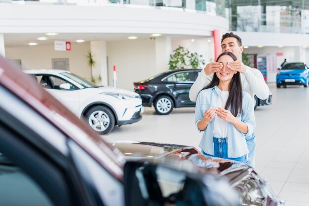 Pareja feliz en concesionario de coches