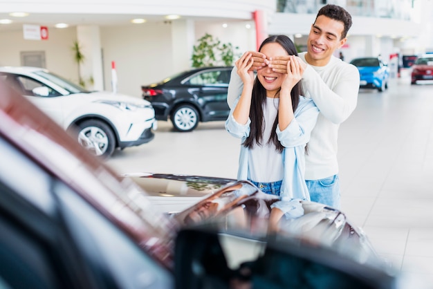 Foto gratuita pareja feliz en concesionario de coches