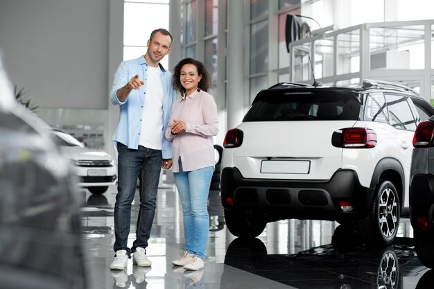 Pareja feliz en concesionario de sala de exposición de coches