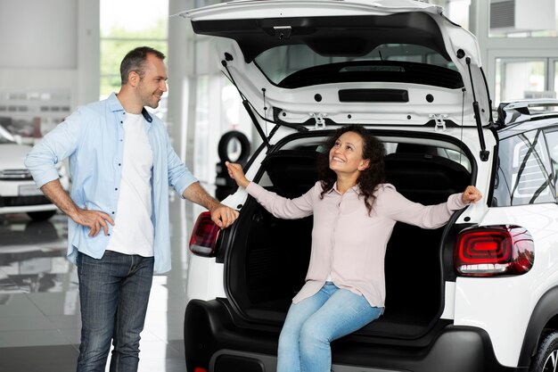 Pareja feliz en concesionario de sala de exposición de coches