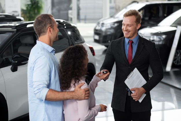 Pareja feliz en concesionario de sala de exposición de coches