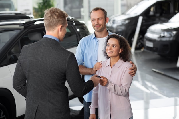 Pareja feliz en concesionario de sala de exposición de coches