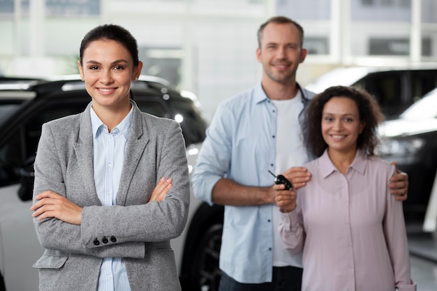 Pareja feliz en concesionario de sala de exposición de coches