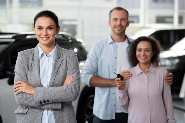 Pareja feliz en concesionario de sala de exposición de coches