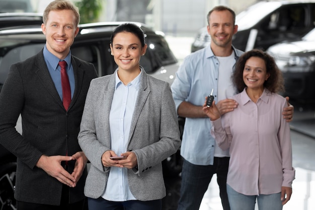 Pareja feliz en concesionario de sala de exposición de coches