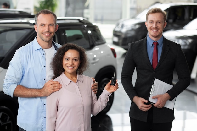 Pareja feliz en concesionario de sala de exposición de coches