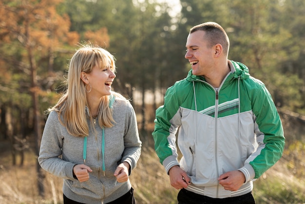 Pareja feliz corriendo juntos en la naturaleza