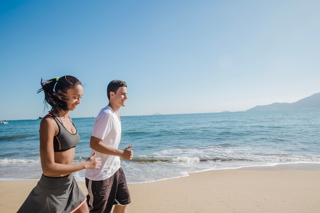 Pareja feliz corriendo en la playa