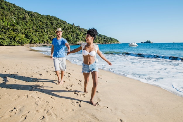 Pareja feliz corriendo en la playa