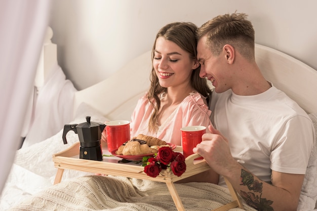 Foto gratuita pareja feliz desayunando en la cama